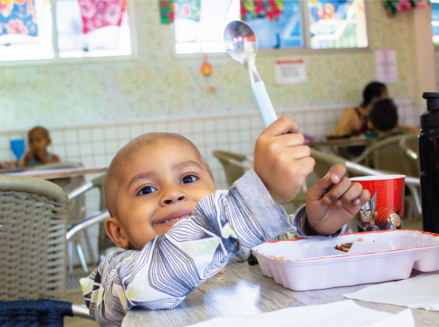 Criança assistida se alimentando